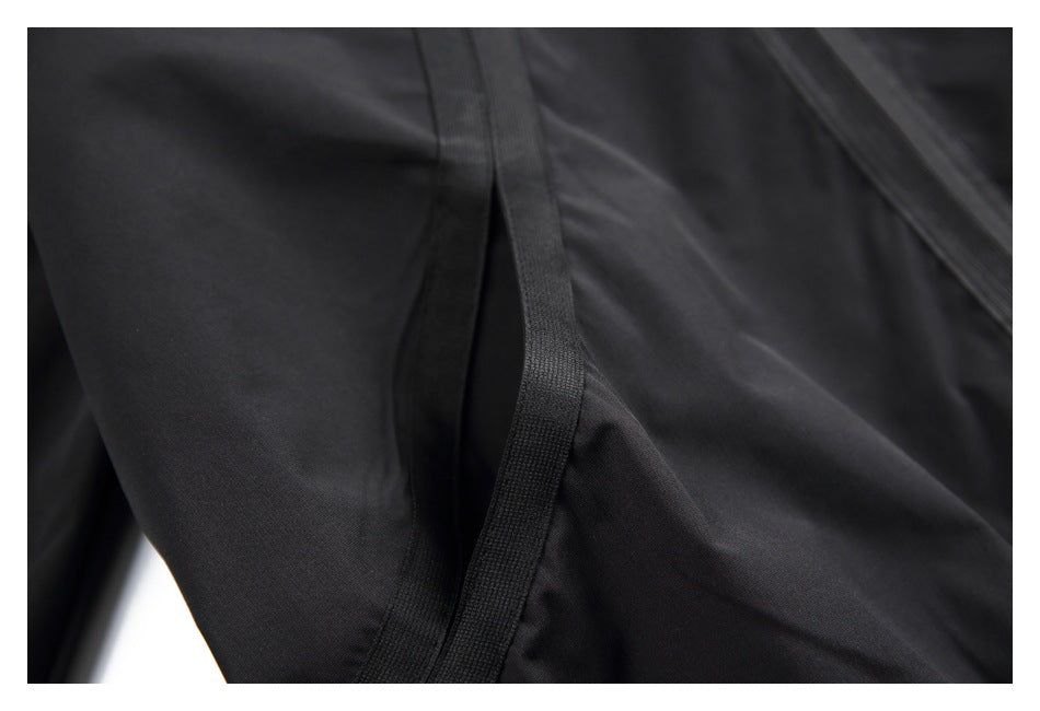 Close-up of black garment fabric and a narrow curved stitched trim.