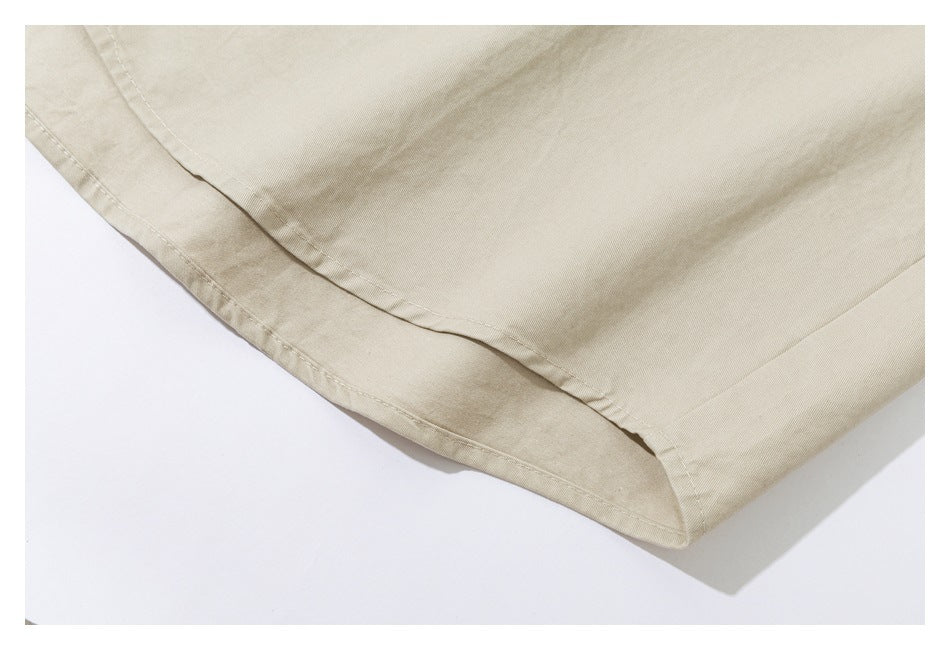 Close-up of a beige garment's curved hem and stitched edge.