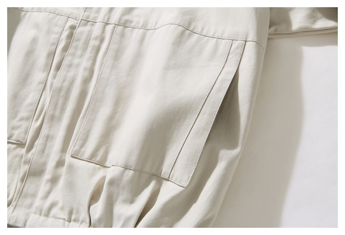 Close-up of a large rectangular patch pocket on an ivory jacket.