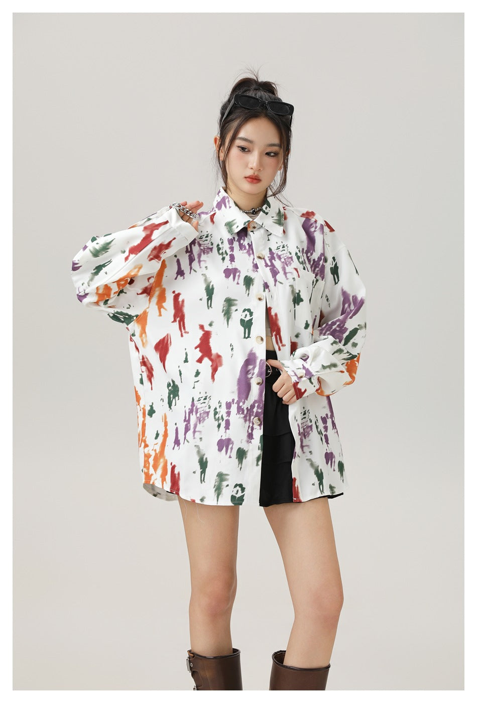 Model wearing an oversized white button-up shirt with colorful abstract prints, shown from the front.