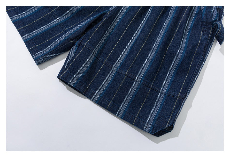 Close-up of dark indigo shorts with blue, white, and thin yellow vertical stripes and finished hems.