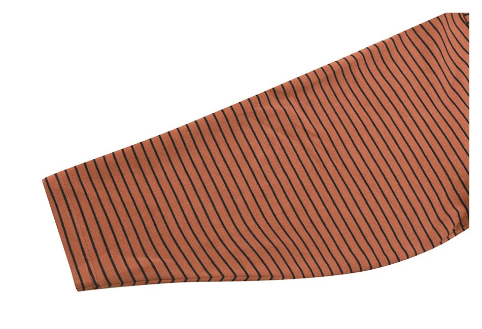Close-up of a rust-orange shirt sleeve with thin black stripes and a finished cuff.