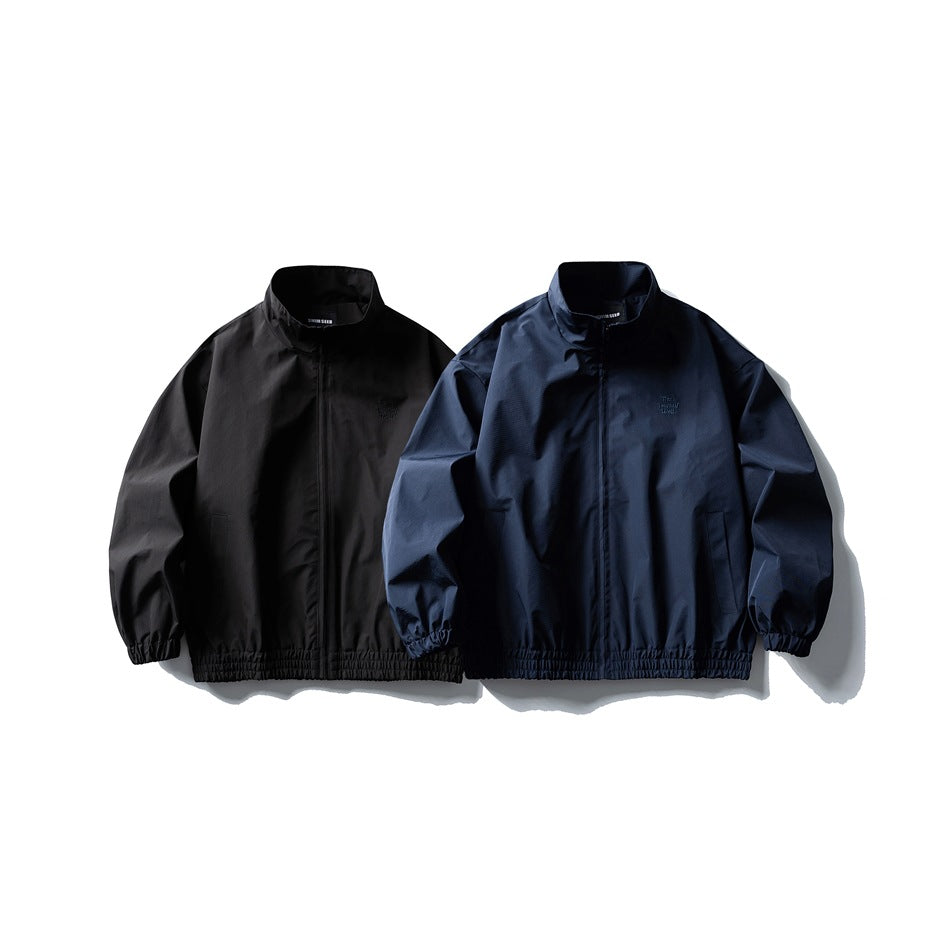 Two front-facing stand-collar jackets with full zips and elastic hems, shown in black and dark navy.