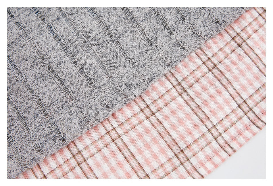 Close-up of gray textured fabric beside pink-and-white plaid fabric.