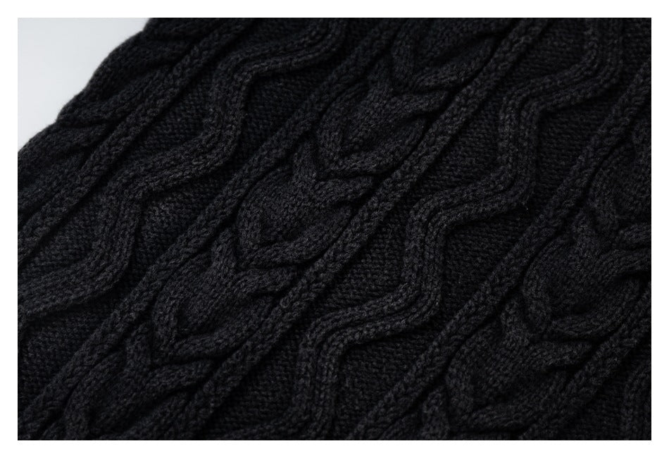 Close-up of black cable-knit fabric with raised braided patterns.