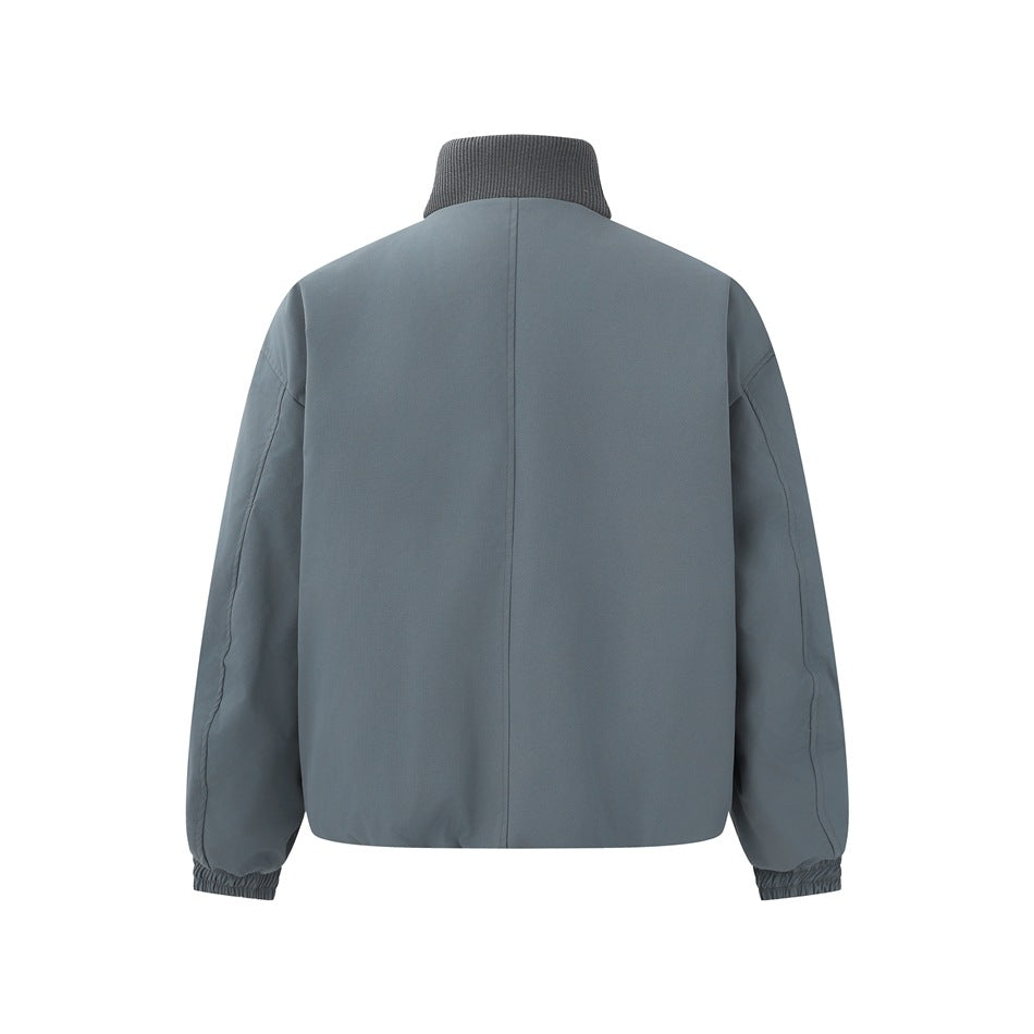 Back view of a slate blue-gray jacket with a ribbed stand collar, center back seam, and gathered cuffs.