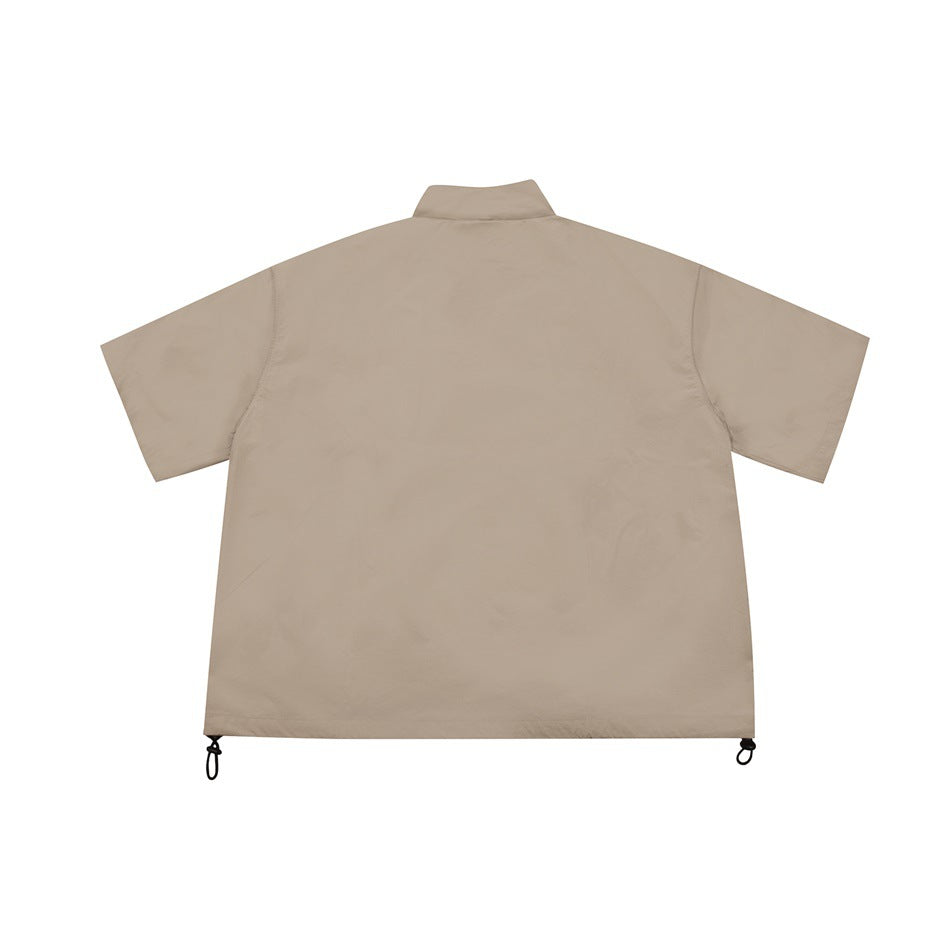 Back view of khaki short-sleeve stand-collar jacket with hem drawcord toggles, flat lay