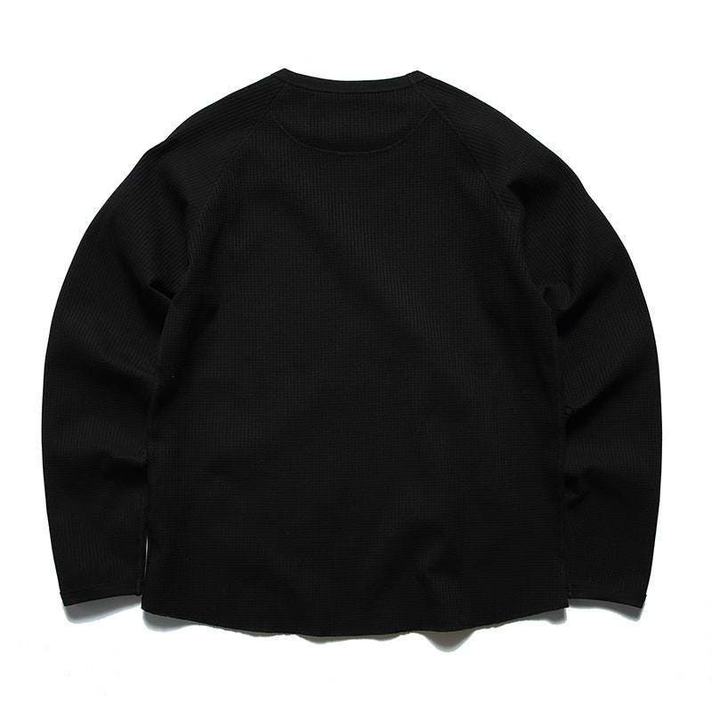 Back view of a black long-sleeve waffle-knit crewneck shirt with raglan seams.
