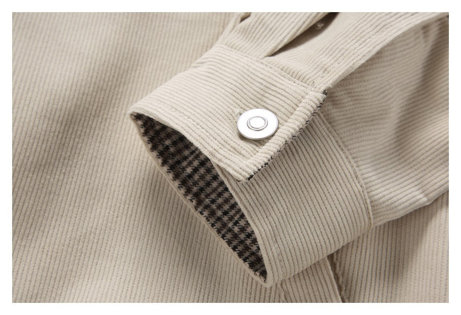 Close-up of a cream ribbed cuff with a round silver snap and dark houndstooth lining.