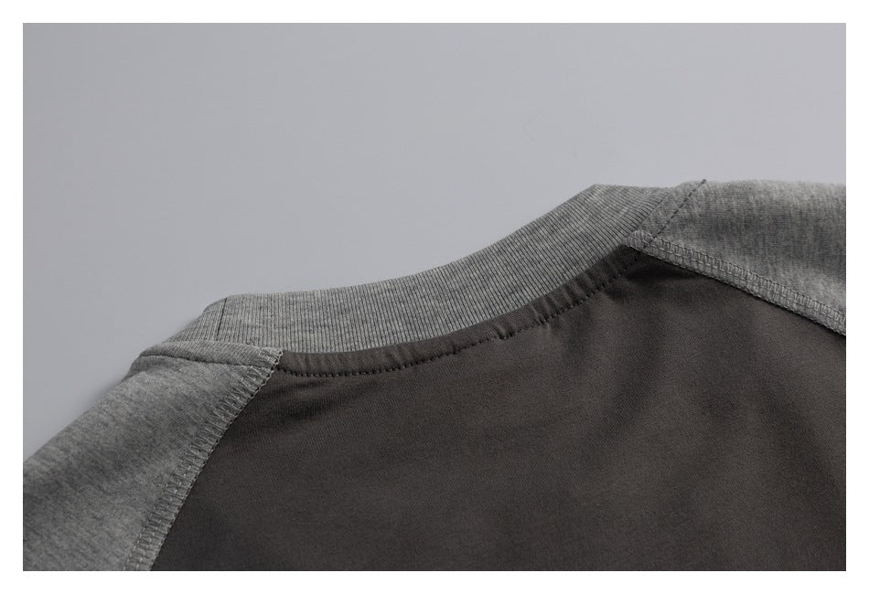 Close-up of the garment's ribbed gray neckline and shoulder seams against a charcoal body.