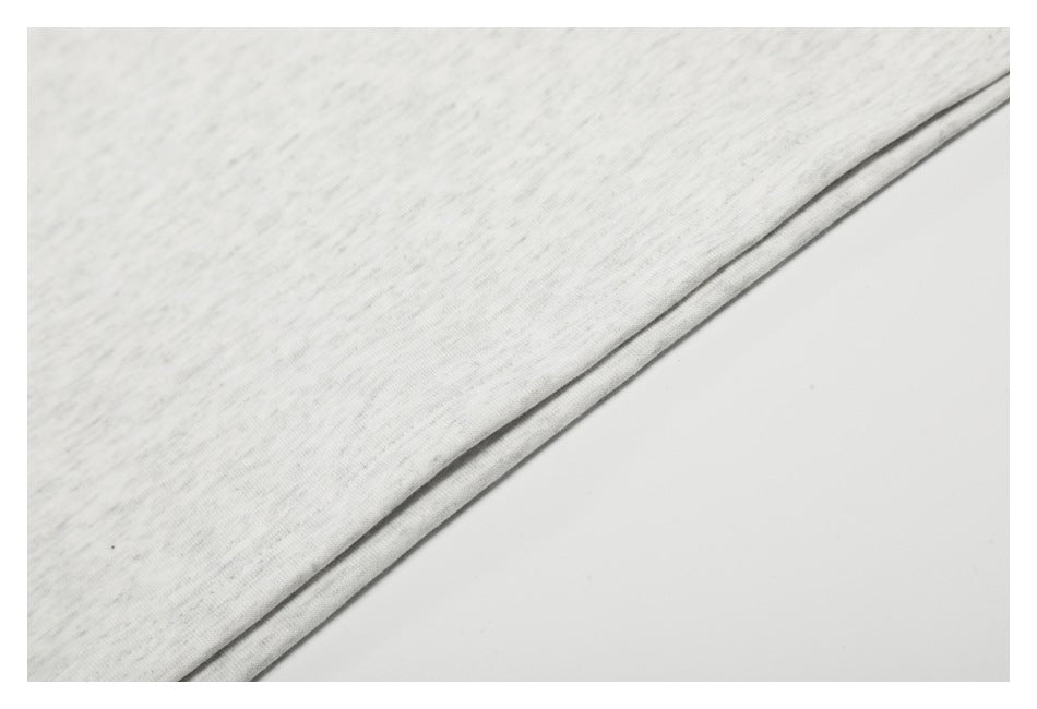 Close-up of the straight bottom hem on light gray marled T-shirt fabric.
