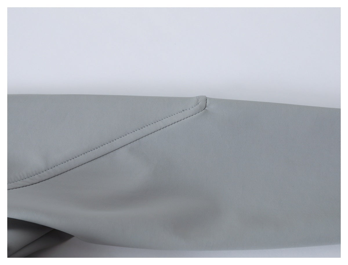 Close-up of a light gray garment panel with curved stitched seam detailing.