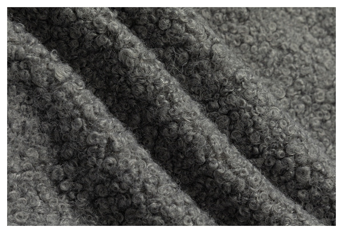 Close-up of layered folds of gray fabric with a dense, curly looped texture.