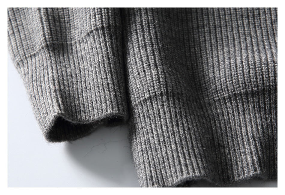 Close-up of the gray cardigan's ribbed sleeve cuff and lower body hem laid flat.