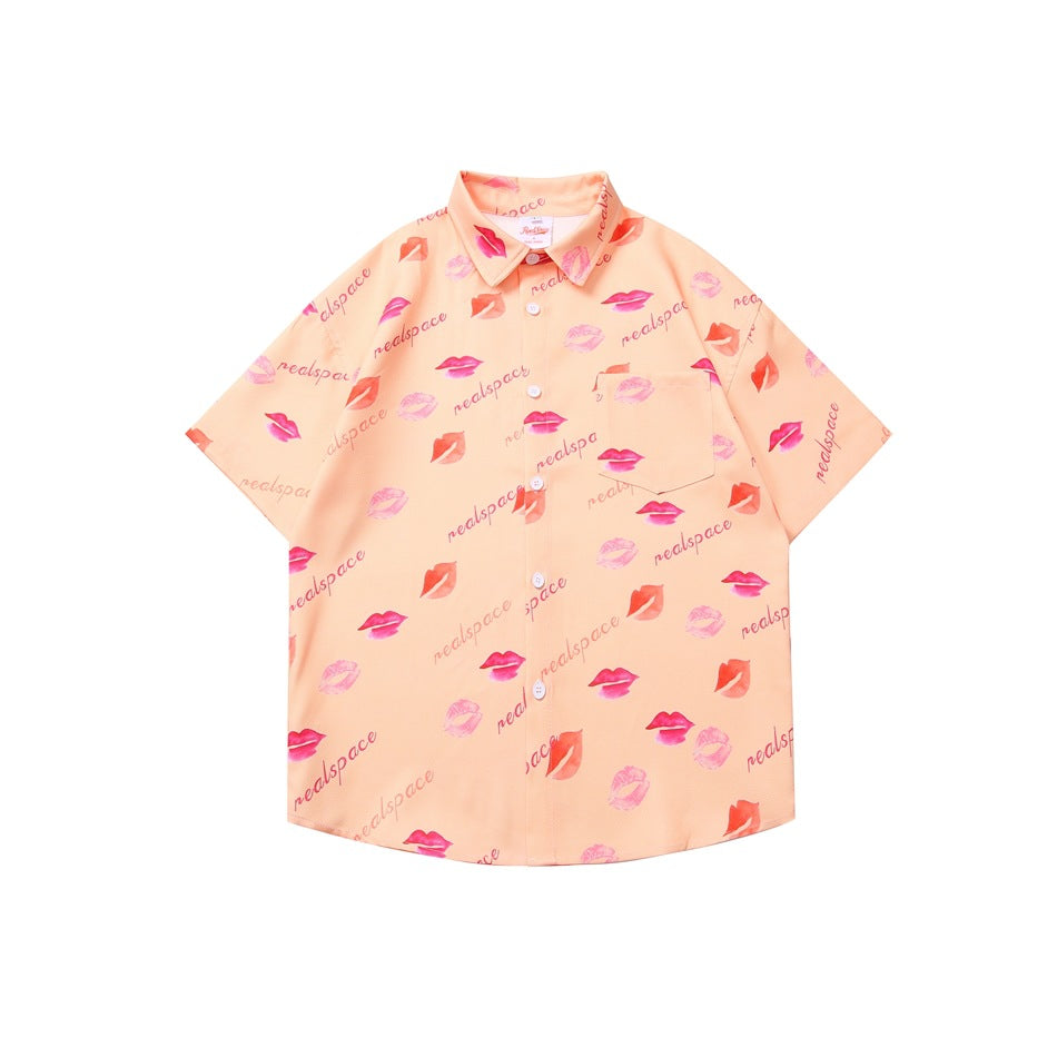 Peach pink short-sleeve button-up shirt with all-over lip and script print, flat lay front view