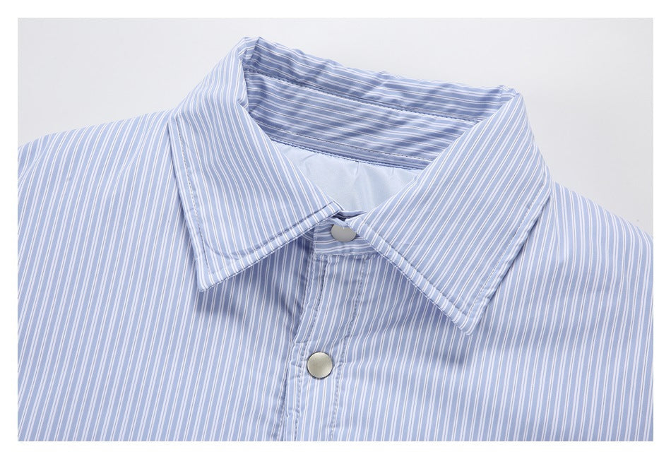 Close-up of a pointed collar and snap placket on a pale blue and white striped shirt.