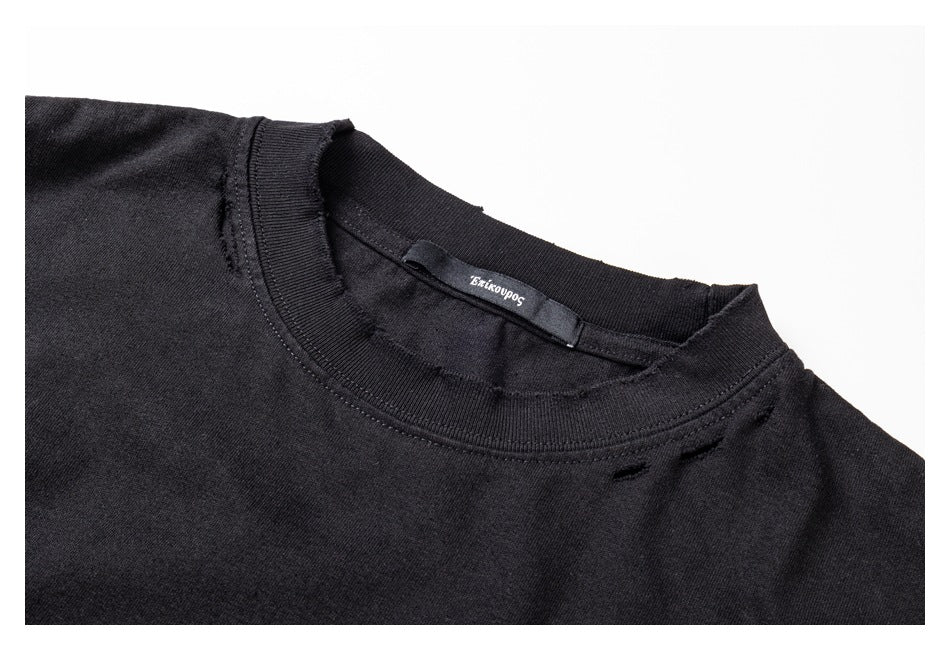 Close-up of the black shirt's ribbed crew neck, inner label, and small distressed openings.