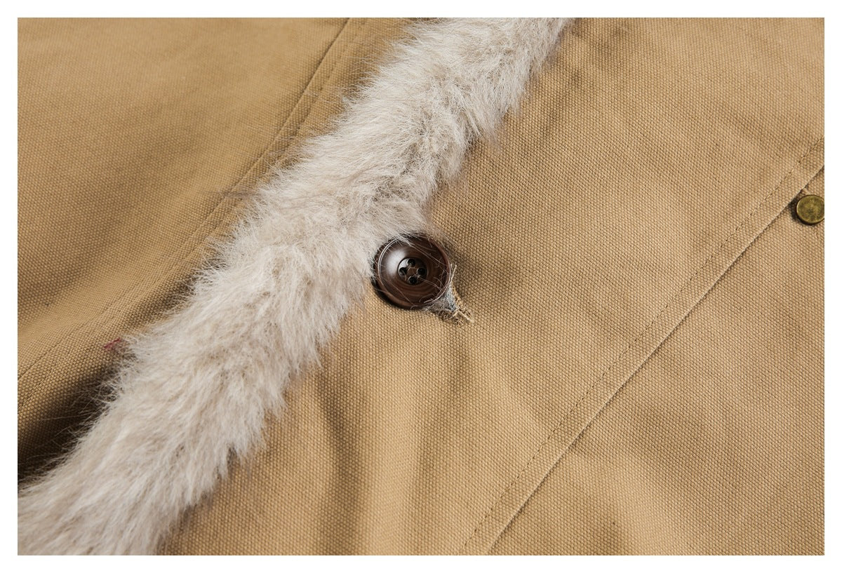 Close-up of a dark brown button, light fur trim, and stitched tan jacket fabric.