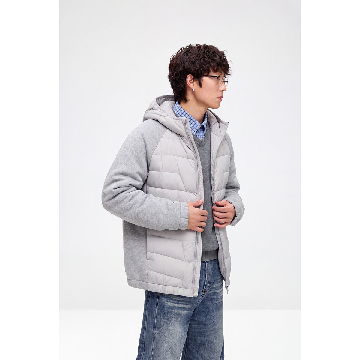 Model wearing a light gray hooded jacket with quilted front panels and contrasting solid gray sleeves.