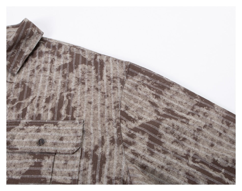Close-up of the taupe shirt's patterned shoulder, sleeve, and flap chest pocket.