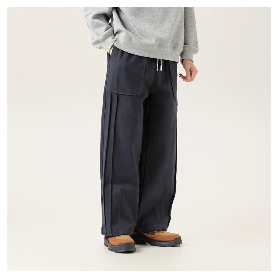 Person wearing navy wide-leg sweatpants with a gray sweatshirt and tan hiking-style shoes, front three-quarter view