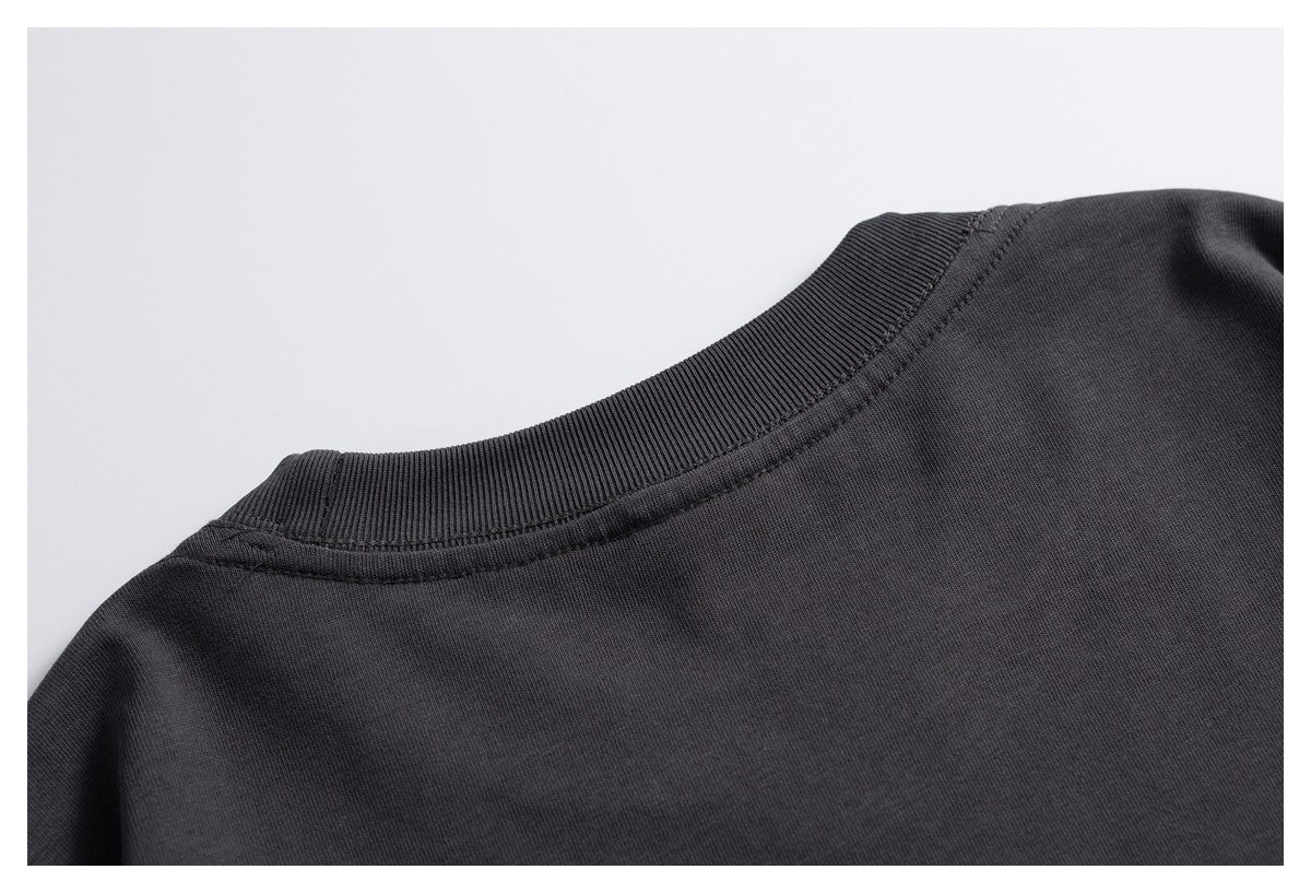 Close-up of the back neckline and shoulder seam of a charcoal T-shirt.