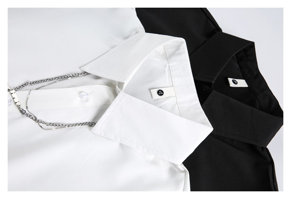 Close-up of white and black shirt collars with size labels and silver chain decorations.