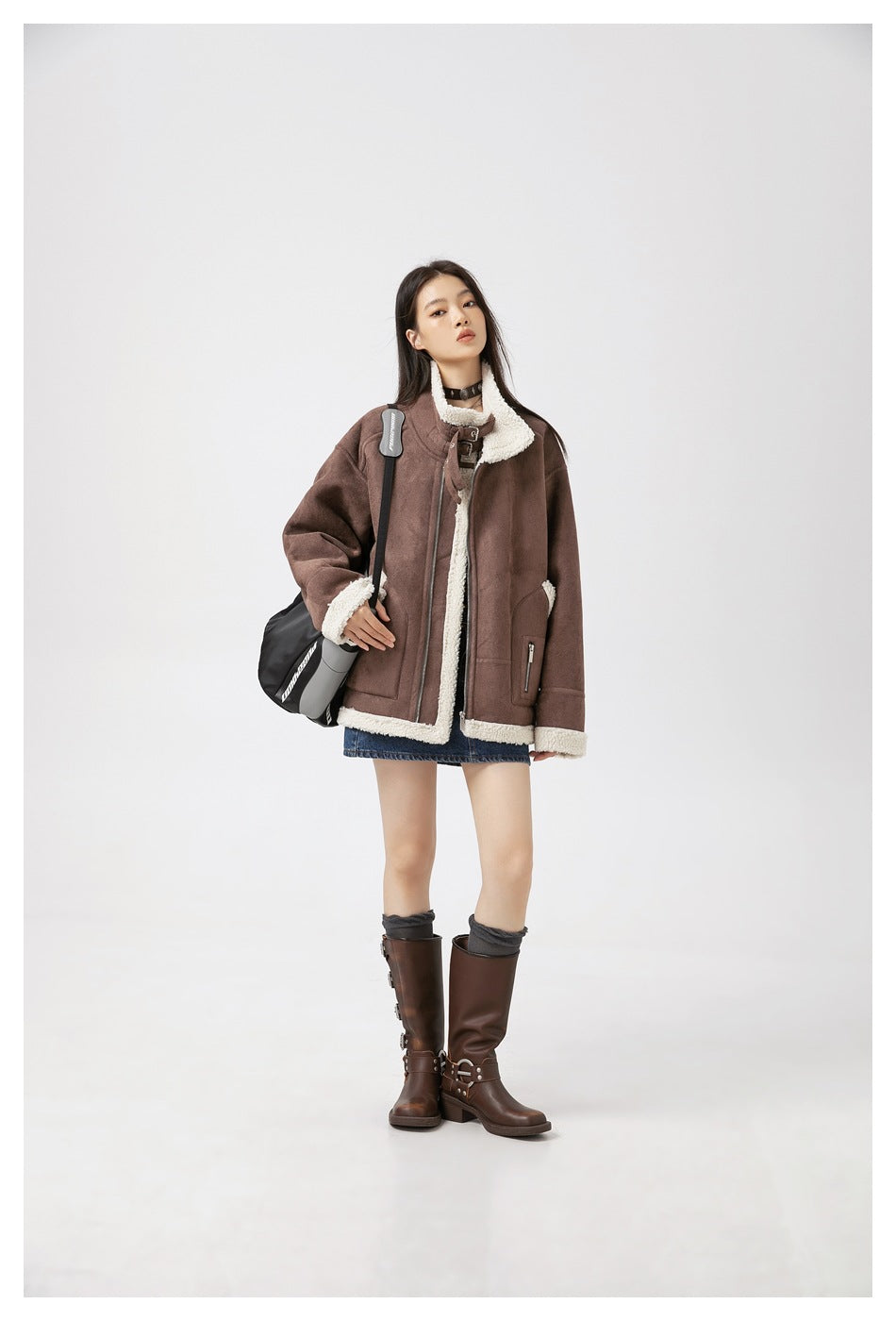 Full-length model wearing a brown sherpa-trimmed jacket, denim shorts and tall brown boots.
