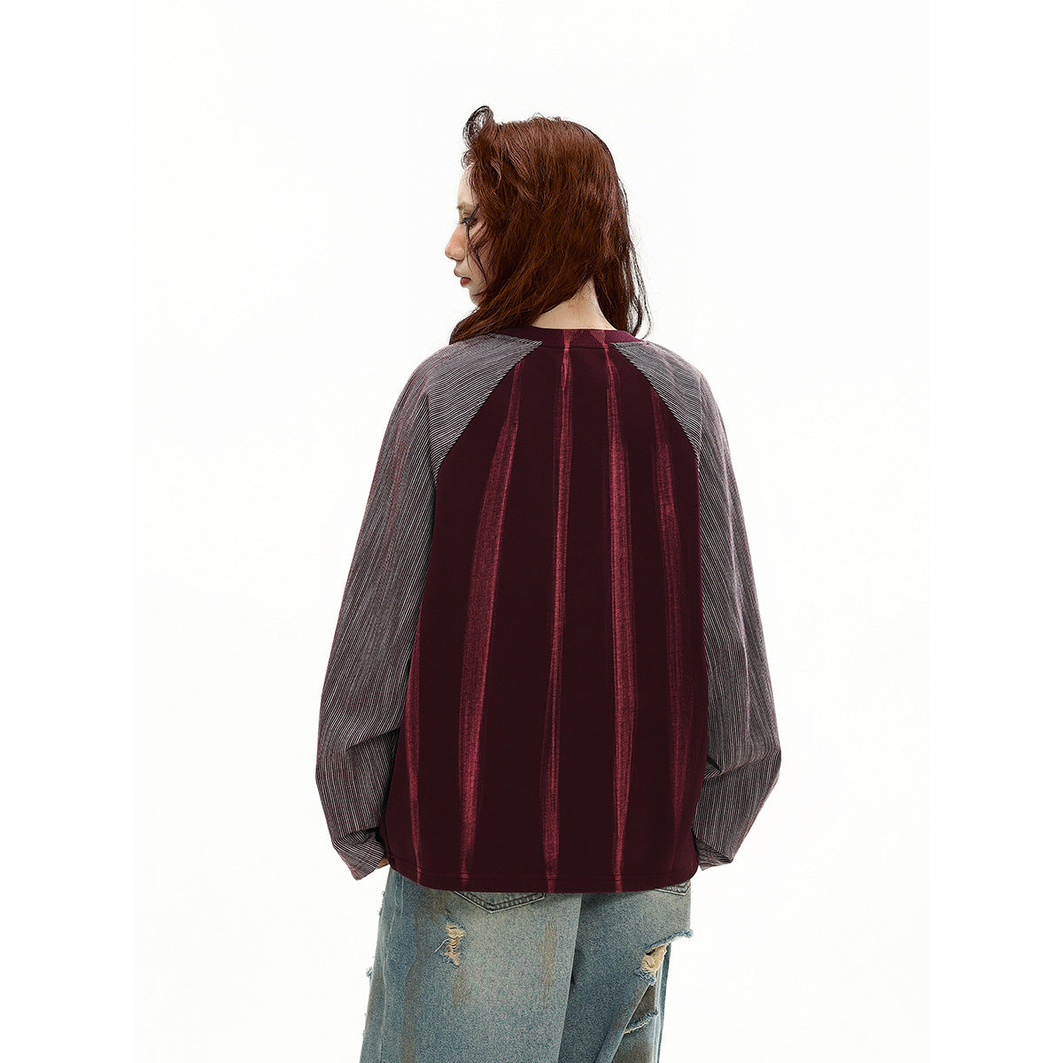 Rear view of a model wearing a burgundy striped top with gray pinstriped raglan sleeves.