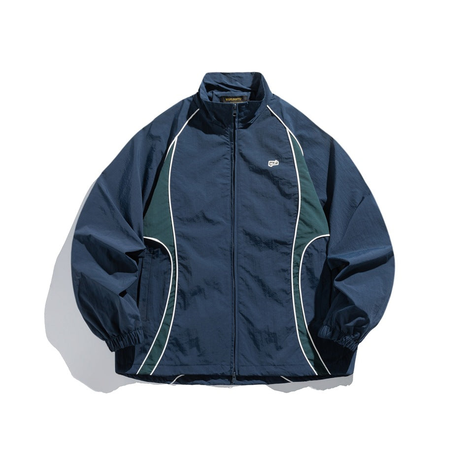Navy blue zip-up stand-collar jacket with green side panels, white piping and elastic cuffs, front flat view