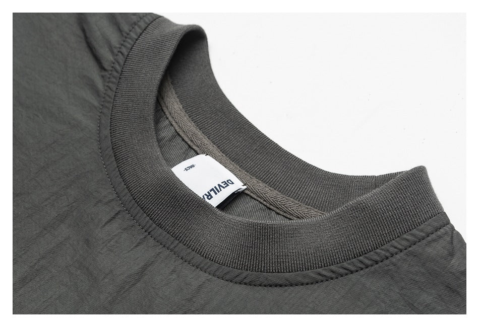 Close-up of a charcoal-gray ribbed crew neckline and sewn-in white label.