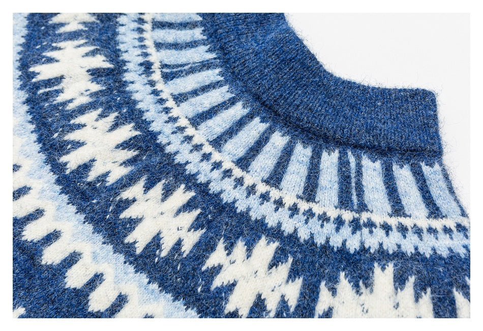 Close-up of a blue sweater's ribbed collar and white geometric knit yoke.