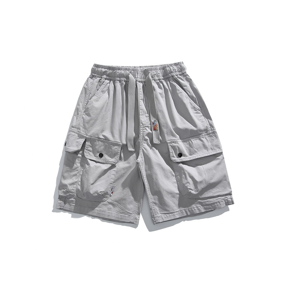 Light gray cargo shorts flat lay with drawstring waist and large flap cargo pockets with snap closures