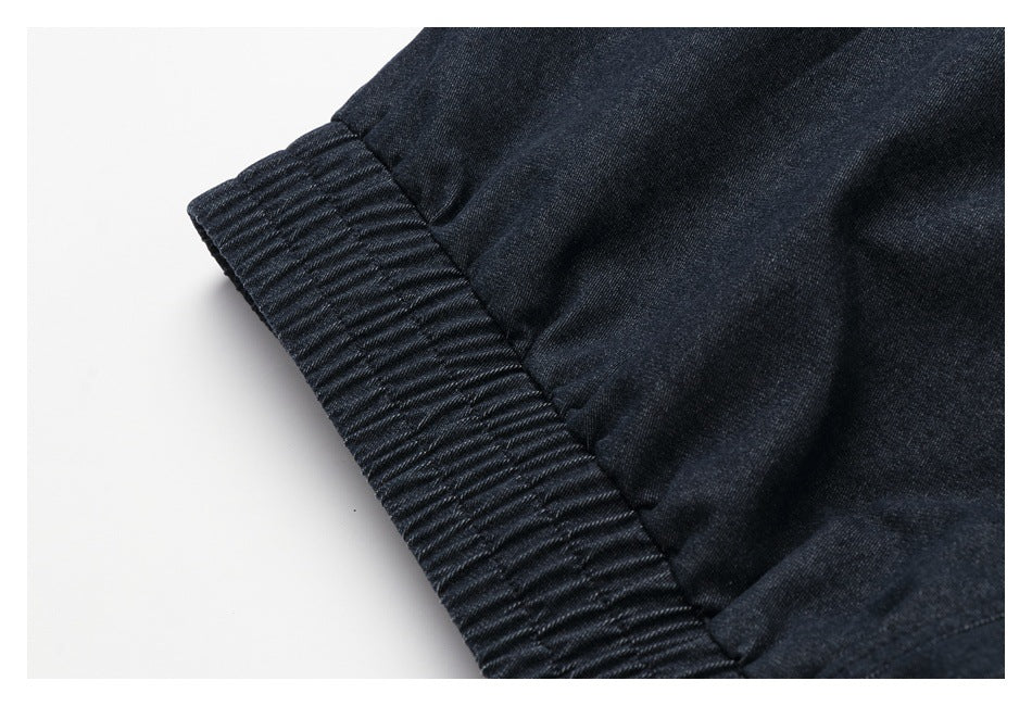 Close-up of a dark navy garment edge with a wide ribbed elastic band and gathered stitching.