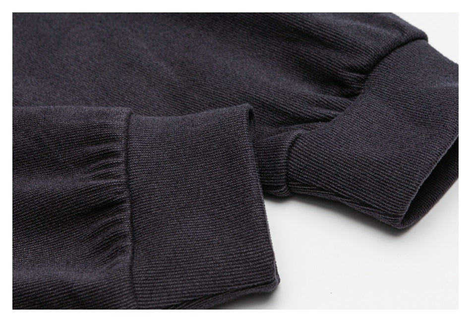 Close-up of a dark garment sleeve and ribbed cuff with stitching.