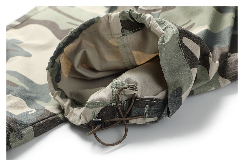Close-up of the camouflage trousers' gathered ankle cuff and adjustable drawcord.
