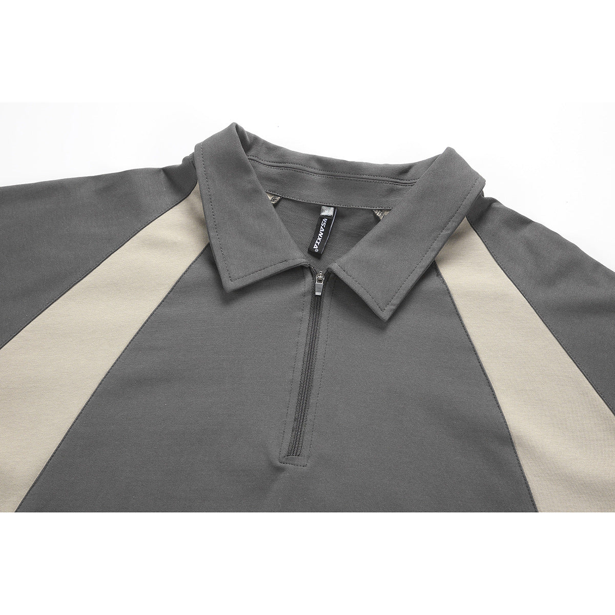 Close-up of a charcoal polo-style shirt with a pointed collar, short zipper, and light beige contrast panels.