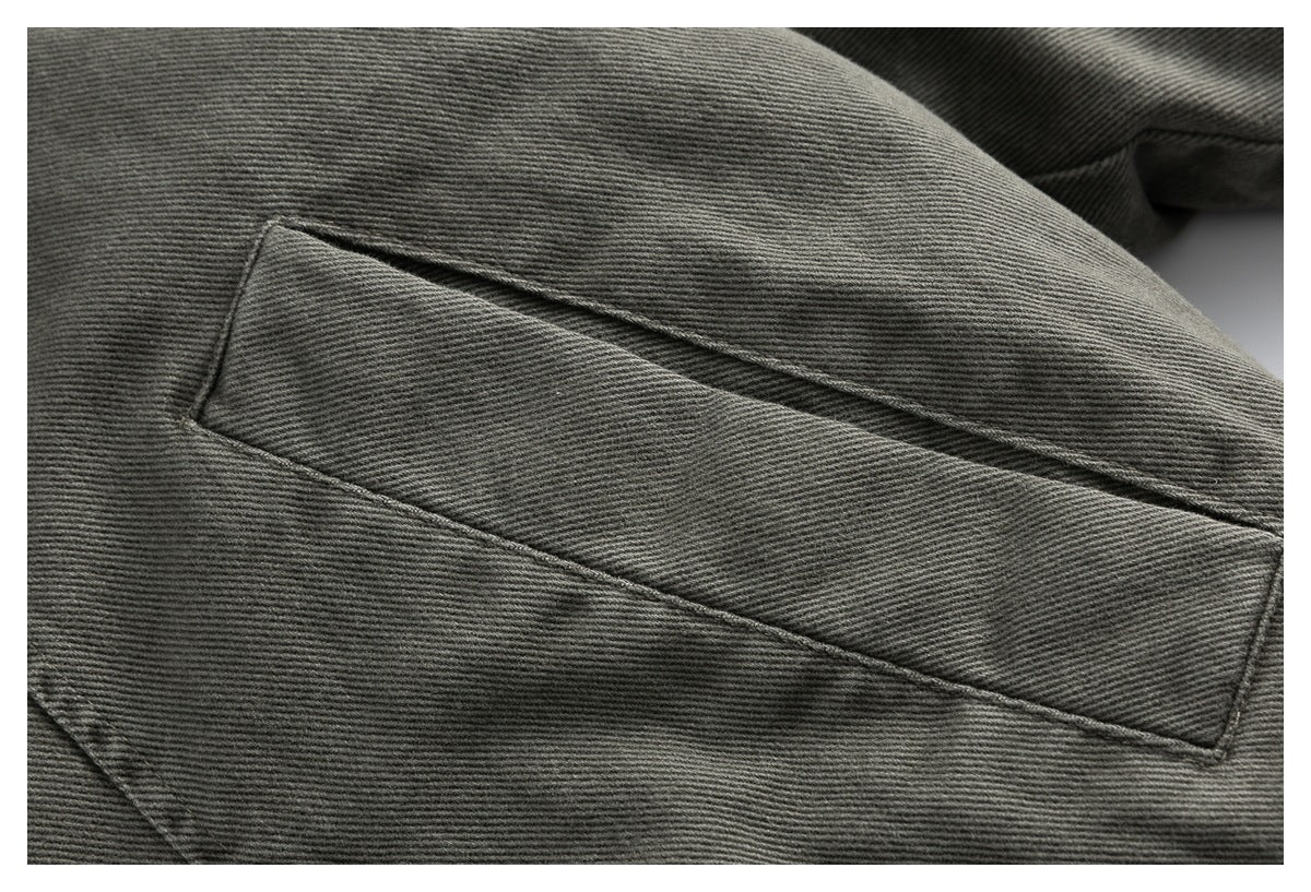 Close-up of a long horizontal welt pocket on the charcoal gray jacket.
