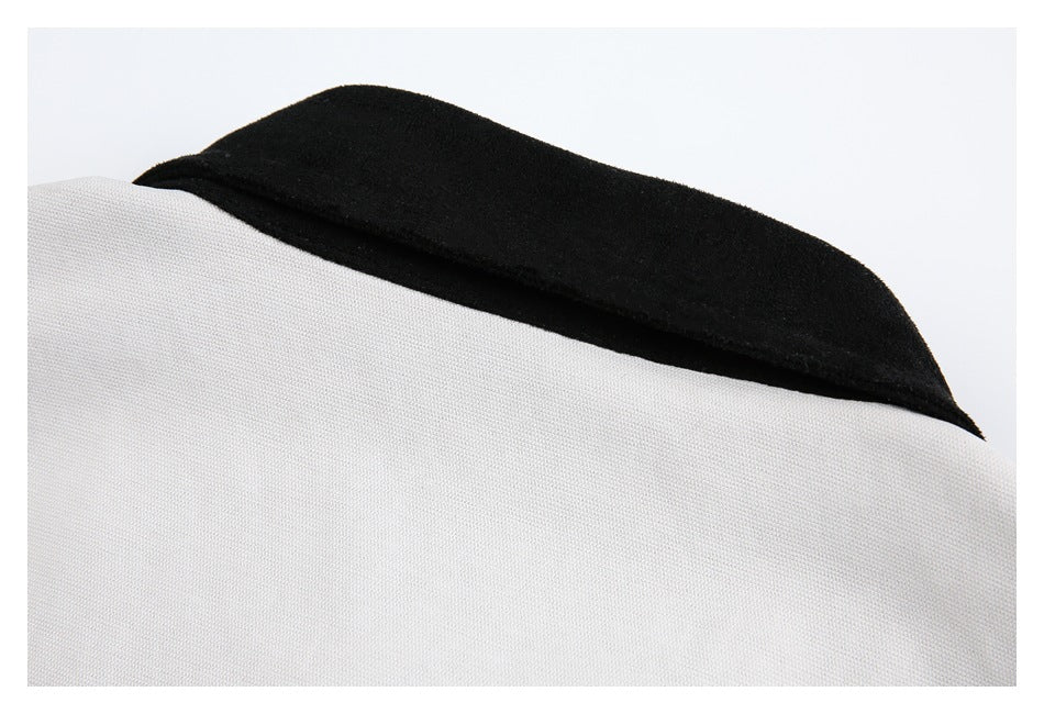 Close-up of a black collar edge against light gray garment fabric.