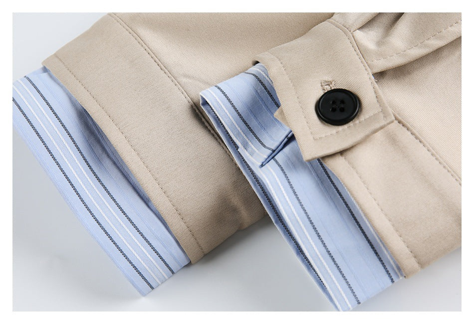 Close-up of beige garment with a black button and light blue striped fabric trim.