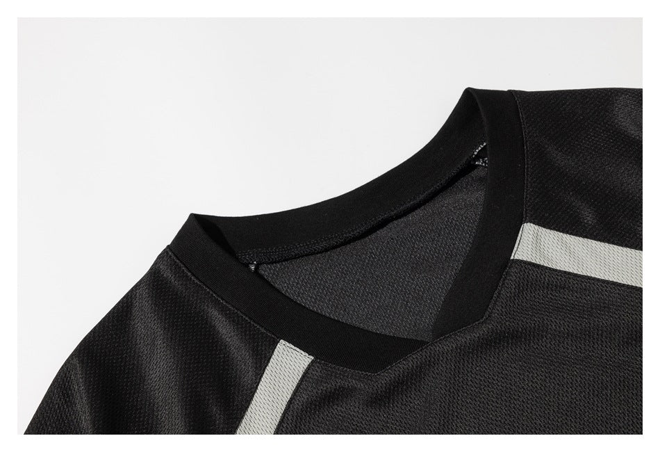 Close-up of the black jersey's V-neck collar, mesh texture, and light gray shoulder stripe.