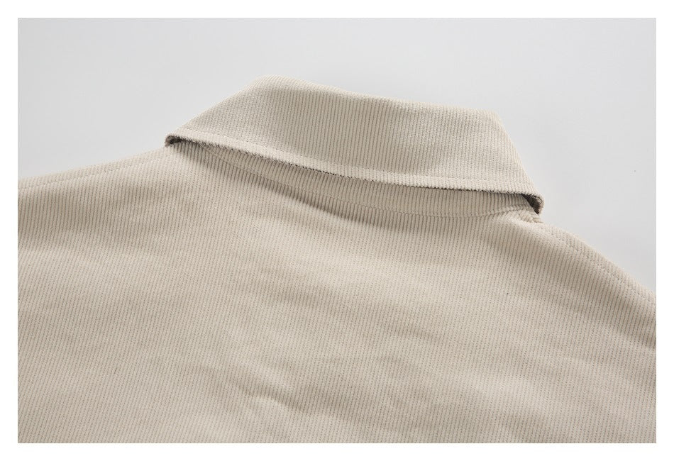 Close-up of the cream ribbed garment's folded collar and upper back seam.