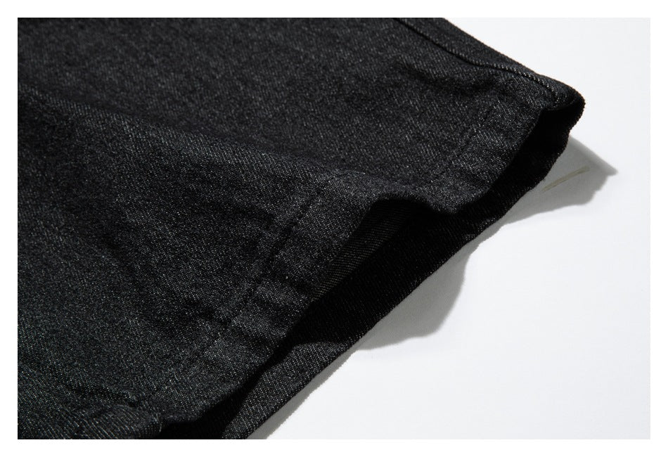 Close-up of a stitched, folded edge on a black garment against a white background.
