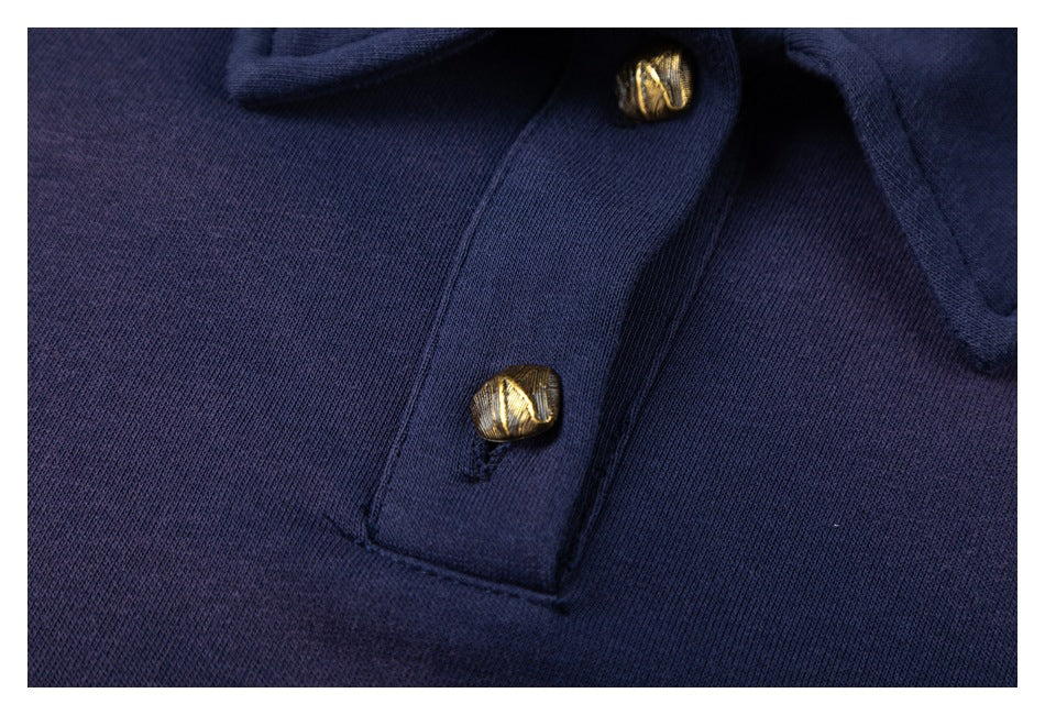 Close-up of two textured gold-tone buttons on the navy sweatshirt's front placket.