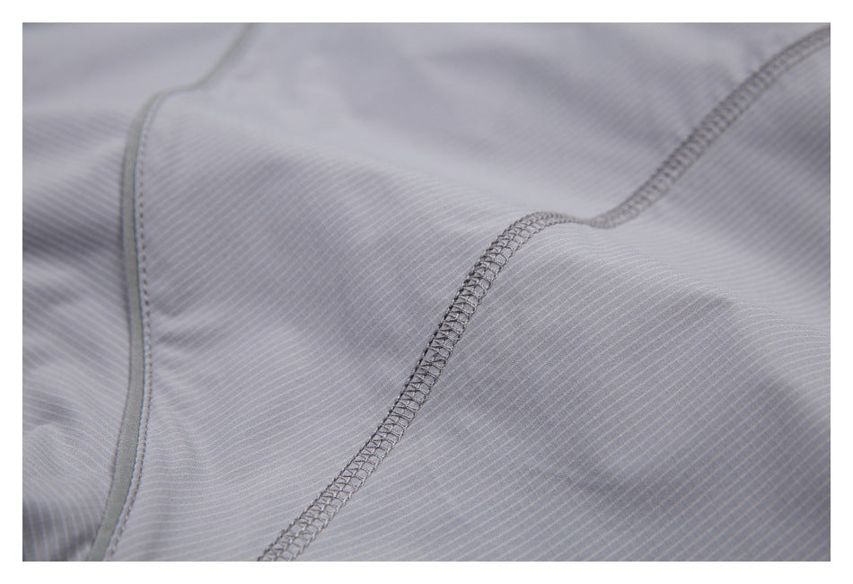 Close-up showing overlock stitching and a bound seam on light gray pinstriped fabric.