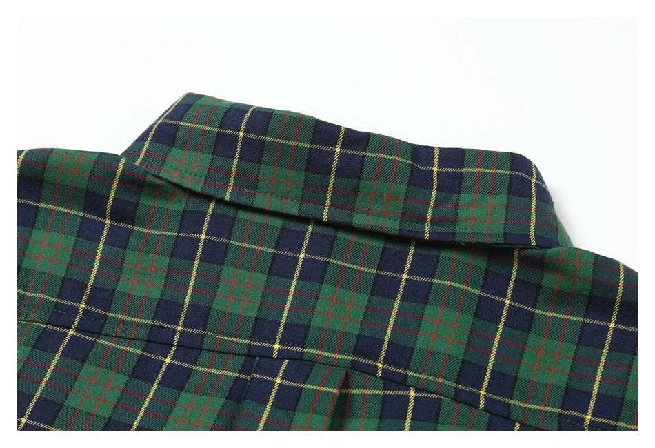 Close-up of a green, navy, red, and yellow plaid shirt collar and upper fabric.