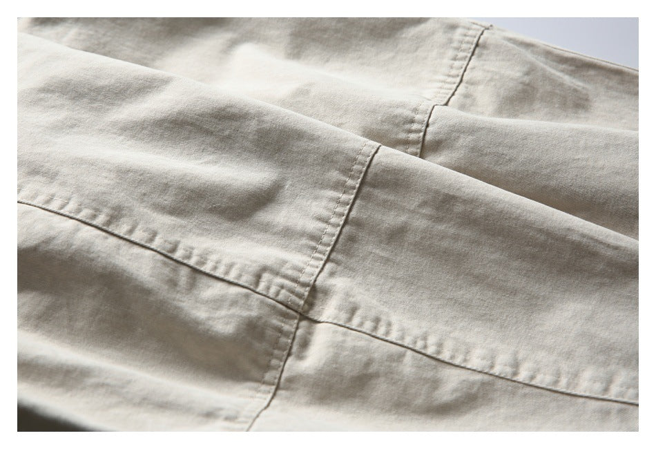 Close-up of stitched panel seams on light beige jacket fabric.