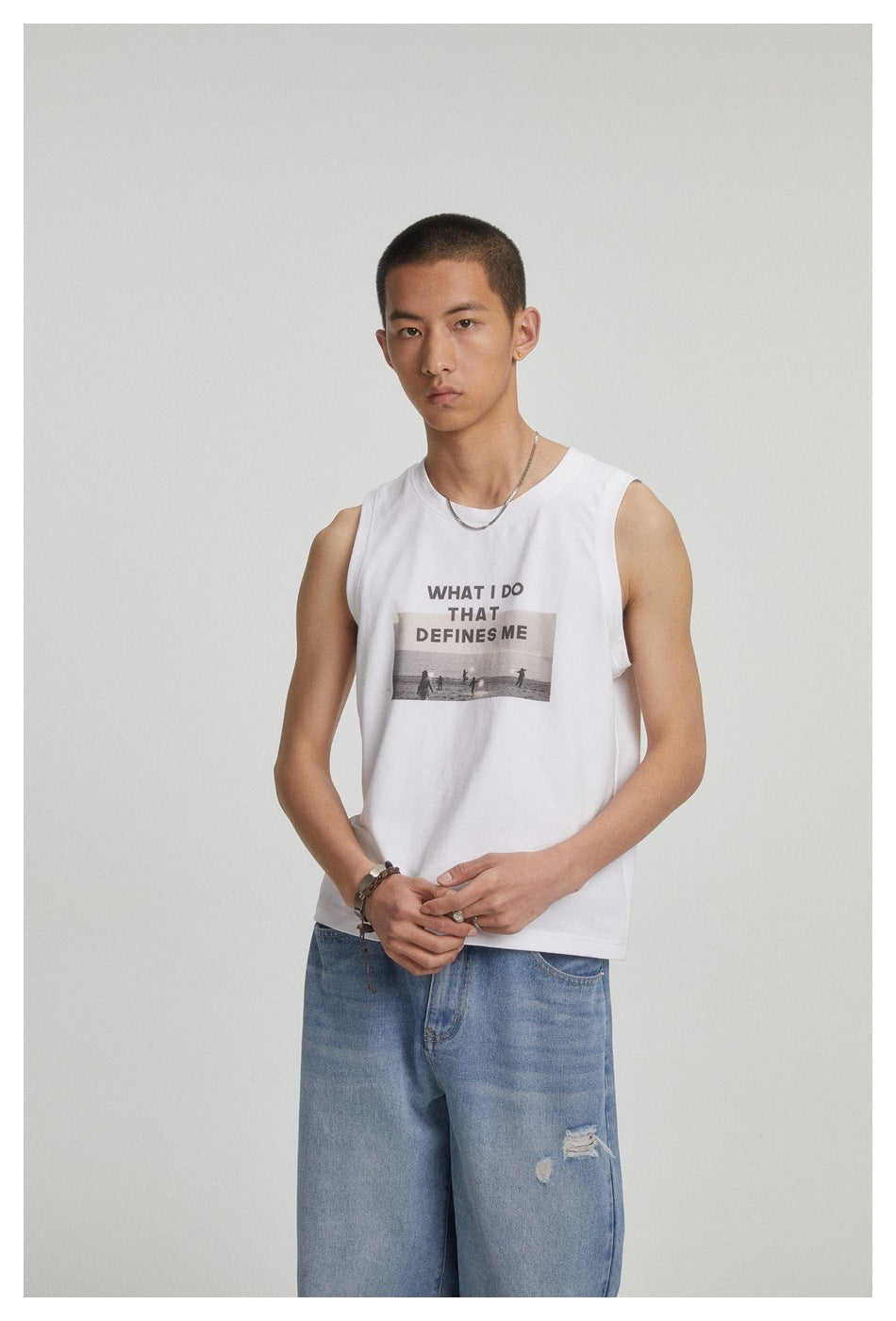 Closer view of a model wearing a white sleeveless shirt with black text and a photo graphic.