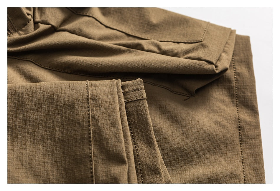 Close-up of a brown garment with grid-textured fabric, stitched seams, and a folded edge.