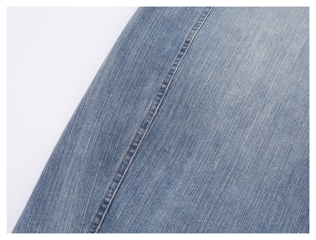 Close-up of light blue denim with a single stitched seam.